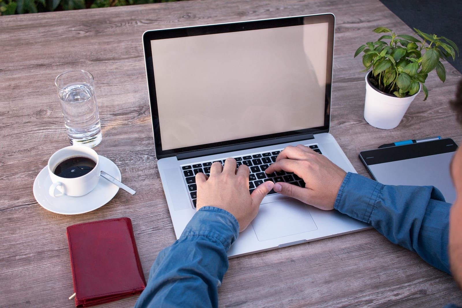 Laptop and an open notebook on a desk, set up for research